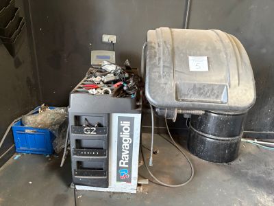 a machine that is sitting next to a trash can in a garage