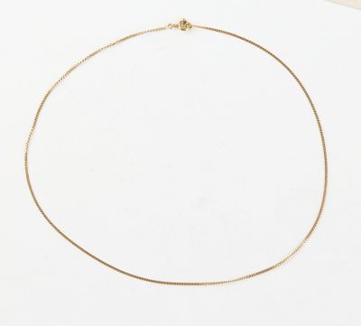 a gold chain necklace with a gold clasp on a white surface