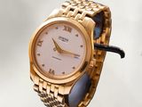 une montre-bracelet en or avec un cadran blanc et un bracelet en or