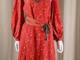 a mannequin wearing a red dress with a green belt