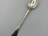 silver spoon on a white surface with a gray background