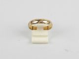 gros plan d'une bague en or sur une surface blanche