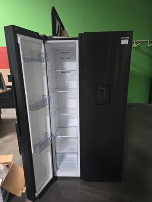 un réfrigérateur noir dont la porte est ouverte, dans une pièce