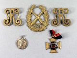 three medals and a medal on a white surface with a coin
