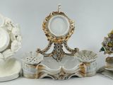 trois figurines en porcelaine assises les unes à côté des autres sur une table