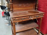 an old wooden desk with a red chair in the background