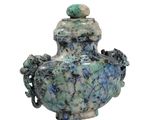 a blue and green vase with a green ball on top