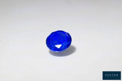 a blue sapphire stone on a white surface