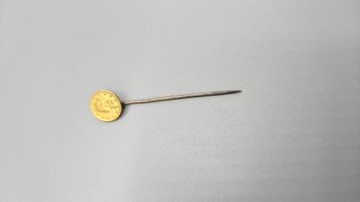 a close up of a gold coin sitting on top of a white surface