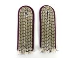 deux paires de poignets brodés, ornés de franges et de pompons