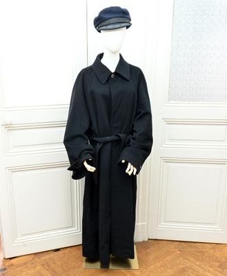 un mannequin vêtu d'un manteau noir et d'un chapeau
