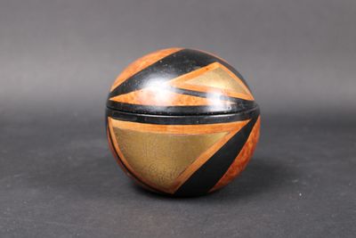 an orange and black striped wooden box sitting on top of a table