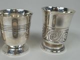 two silver cups sitting next to each other on a table