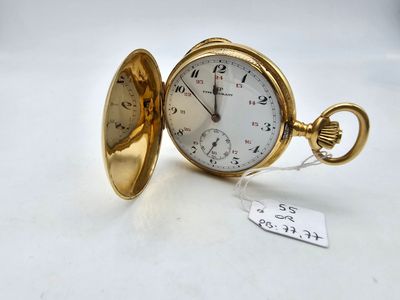 une photo d'une montre de poche posée sur une table, avec une étiquette indiquant son prix