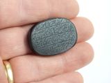 someone is holding a stone with writing on it in their hand