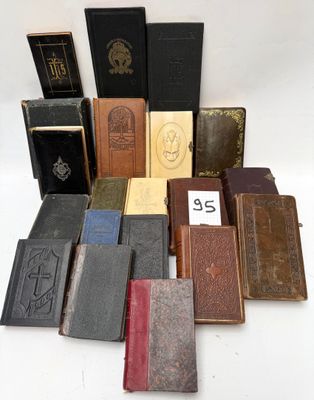 several old books are stacked on top of each other on a white surface