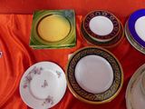 many plates and bowls on a table with a red cloth