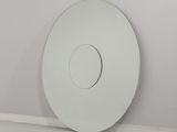 un miroir blanc rond accroché au mur dans un coin de la pièce