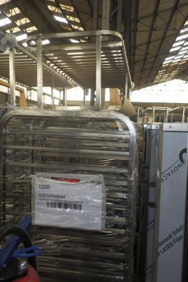 un homme debout à côté d'une pile de bagages dans un entrepôt
