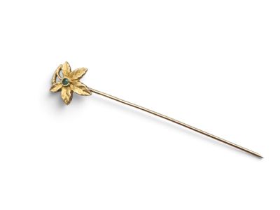 a close up of a gold flower on a stick on a white background
