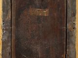 an old wooden picture frame with a rusted surface on a yellow wall