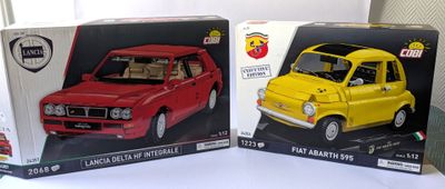 deux modèles d'une petite voiture dans des boîtes sur une table