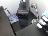 un ordinateur de bureau posé sur un bureau, à côté d'une lampe