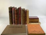 Plusieurs vieux livres sont empilés sur une table blanche, à côté d'une pile de livres