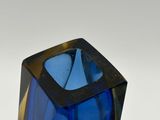 an image of a blue glass vase sitting on top of a white surface