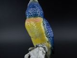 a figurine of a parrot sitting on a branch