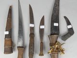 several knives are lined up on a table with tags on them