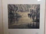 a black and white photo of a river with trees