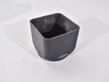 a black cup that is sitting on a white table