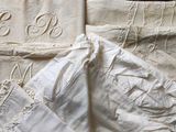 three white linens that have been embroidered with the names of the bride and grooms