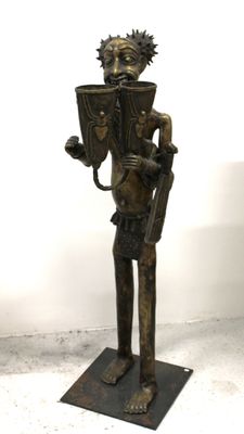 statue en bronze représentant un homme tenant un panier et une coupe
