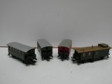 trois petits trains miniatures posés sur une surface blanche, avec un fond blanc