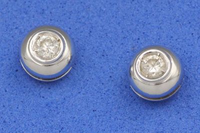 une paire de boucles d'oreilles en diamant sur un fond bleu