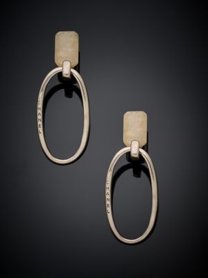 a pair of silver and gold earrings on a black background