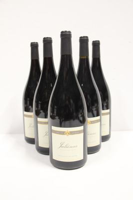 six bottles of red wine are lined up on a white surface
