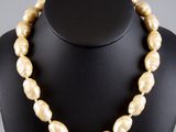 a necklace made of golden pearls on a mannequin