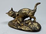 une statue représentant un chat et deux chatons sur un rocher
