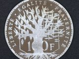 a close up of a silver coin with a tree on it
