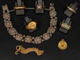 un collier, un bracelet, une bague et d'autres bijoux posés sur une table