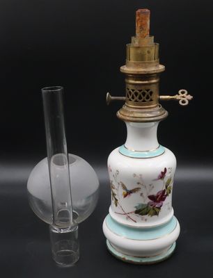 un vase blanc et bleu et un verre posés sur une table