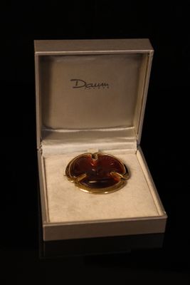 a gold plated broochee in a white box