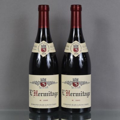 deux bouteilles de vin rouge posées sur une table en verre