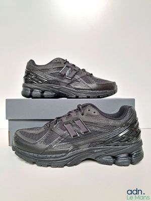 une paire de baskets noires posée sur une boîte