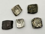 four different types of ancient coins are shown on a white surface