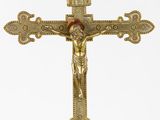 gold cross with crucifix on top of it against a white background