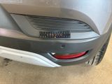 the rear end of a gray car with a number plate on it